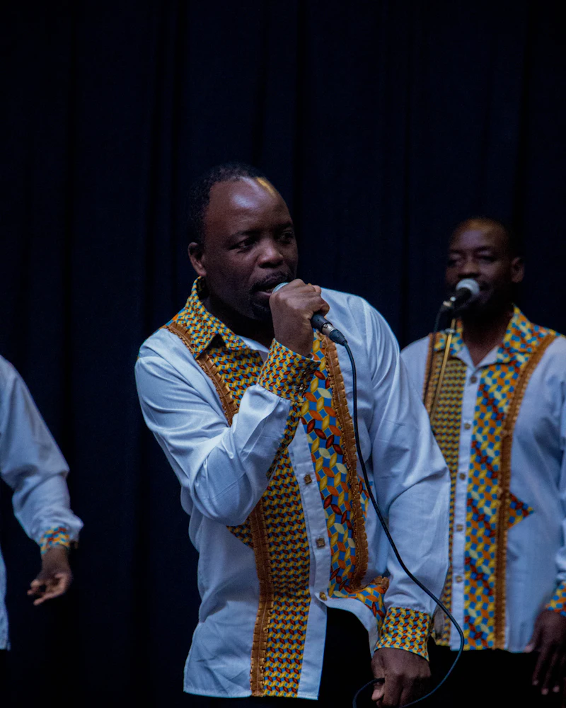 Deux chanteurs en tenue traditionnelle chantent au micro